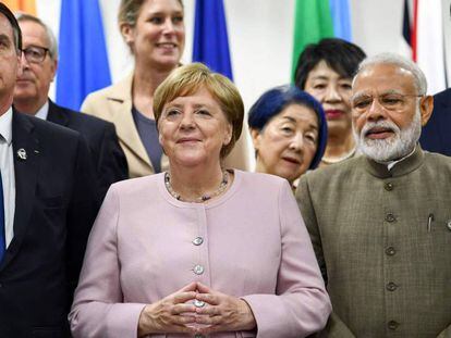 Angela Merkel (centro), en un evento durante la cumbre del G20 en Osaka, este sábado. En vídeo, Merkel sufre temblores durante un acto oficial el pasado jueves en Berlín.