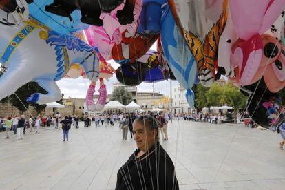 Una dona ven globus en una plaça a Sant Cugat del Vallès.