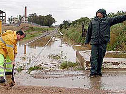 Un operario trataba ayer de acondicionar la vía férrea a su paso por Alcolea del Río (Sevilla).