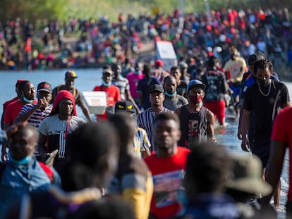 Haiti migrants waiting in Del Rio and Ciudad Acuña to get access to the United States, cross the Rio Grande toward Ciudad Acuña to get supplies, Friday, Sept. 17, 2021, in Ciudad Acuña, Mexico. Haitians crossed the Rio Grande freely and in a steady stream, going back and forth between the U.S. and Mexico through knee-deep water with some parents carrying small children on their shoulders. Unable to buy supplies in the U.S., they returned briefly to Mexico for food and cardboard to settle, temporarily at least, under or near the bridge in Del Rio, a city of 35,000 that has been severely strained by migrant flows in recent months. (Marie D. De Jesús/Houston Chronicle via AP)