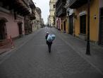 A man walks down a street empty of traffic because of the pandemic lockdown, in downtown Lima, Peru, Sunday, June 14, 2020. (AP Photo/Rodrigo Abd)