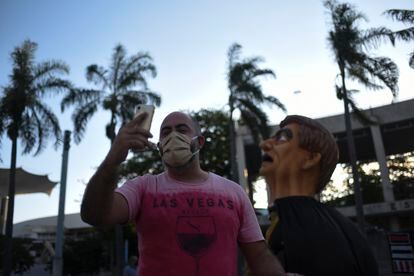 Un seguidor de Bolsonaro se toma una selfi con un muñeco de la imagen del presidente en el estadio Maracana.