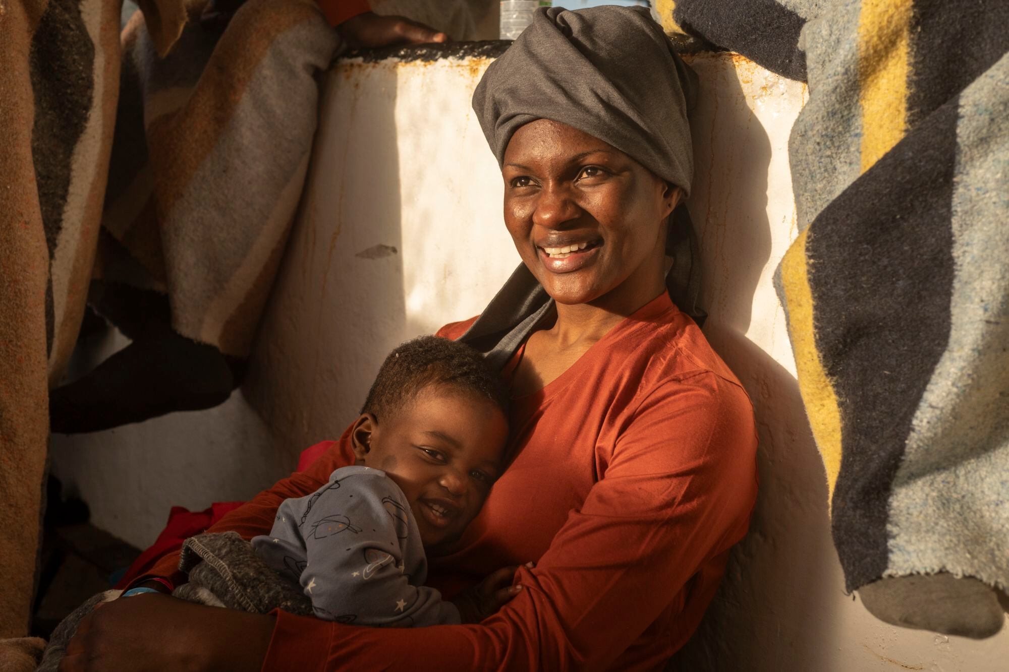 Hadiya, la madre de Amala, descansa en la cubierta junto a su bebé. Logró escapar de Libia después de tres años. Allí había llegado siendo aún menor, huyendo de los malos tratos de su padre. Fue víctima de mutilación genital femenina a los dos años.