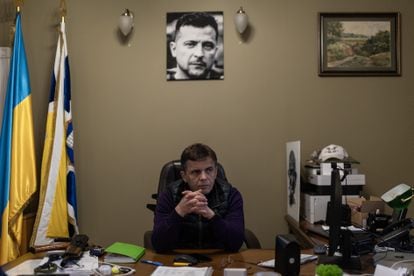 Serhii Sukhomlin, mayor of Yitomir, on Wednesday, in his office under a photograph of Ukrainian President Volodymyr Zelensky, with his Kalashnikov rifle on his desk.