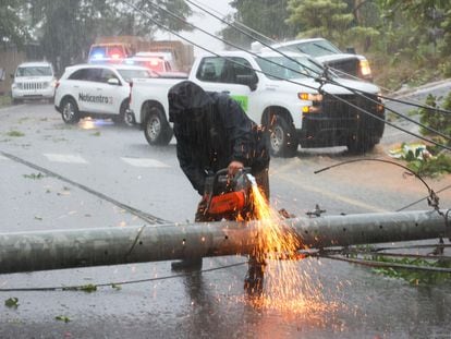 Un trabajador corta un poste de electricidad arruinado por el huracán Fiona, este domingo en Puerto Rico.