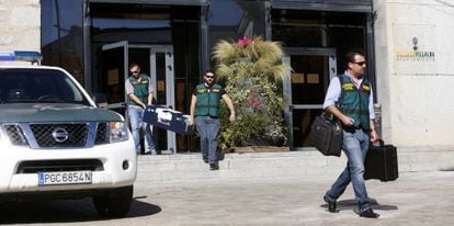 Unos guardias salen tras un registro en el Ayuntamiento madrile&ntilde;o de Collado Villalba.