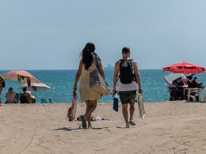 Dos personas se dirigen a la playa de El Saler, en Valencia, el 11 de agosto de 2023.