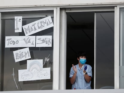 Una enfermera sale a la ventana de una de las habitaciones del Hospital Virgen del Camino de Pamplona para participar también en el aplauso hacia sus compañeros