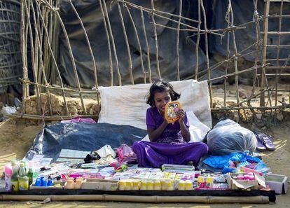 Una niña Rohingya se pinta los labios mientras espera a clientes en un puesto ambulante en el campo de redugiados de Kutupalong en el distrito de Ukhia (Bangladés).