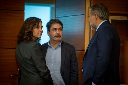 La presidenta de la Comunidad de Madrid, Isabel Díaz Ayuso, con su jefe de prensa, José Luis Carreras, y el consejero de Presidencia, Enrique López, en la puerta del hemiciclo, este jueves.