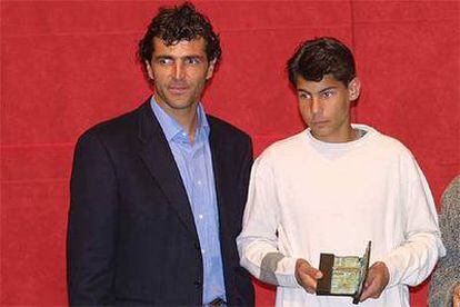 Rafa Nadal, en su época infantil, recoge un trofeo junto a su tío Miquel Àngel, ex futbolista.