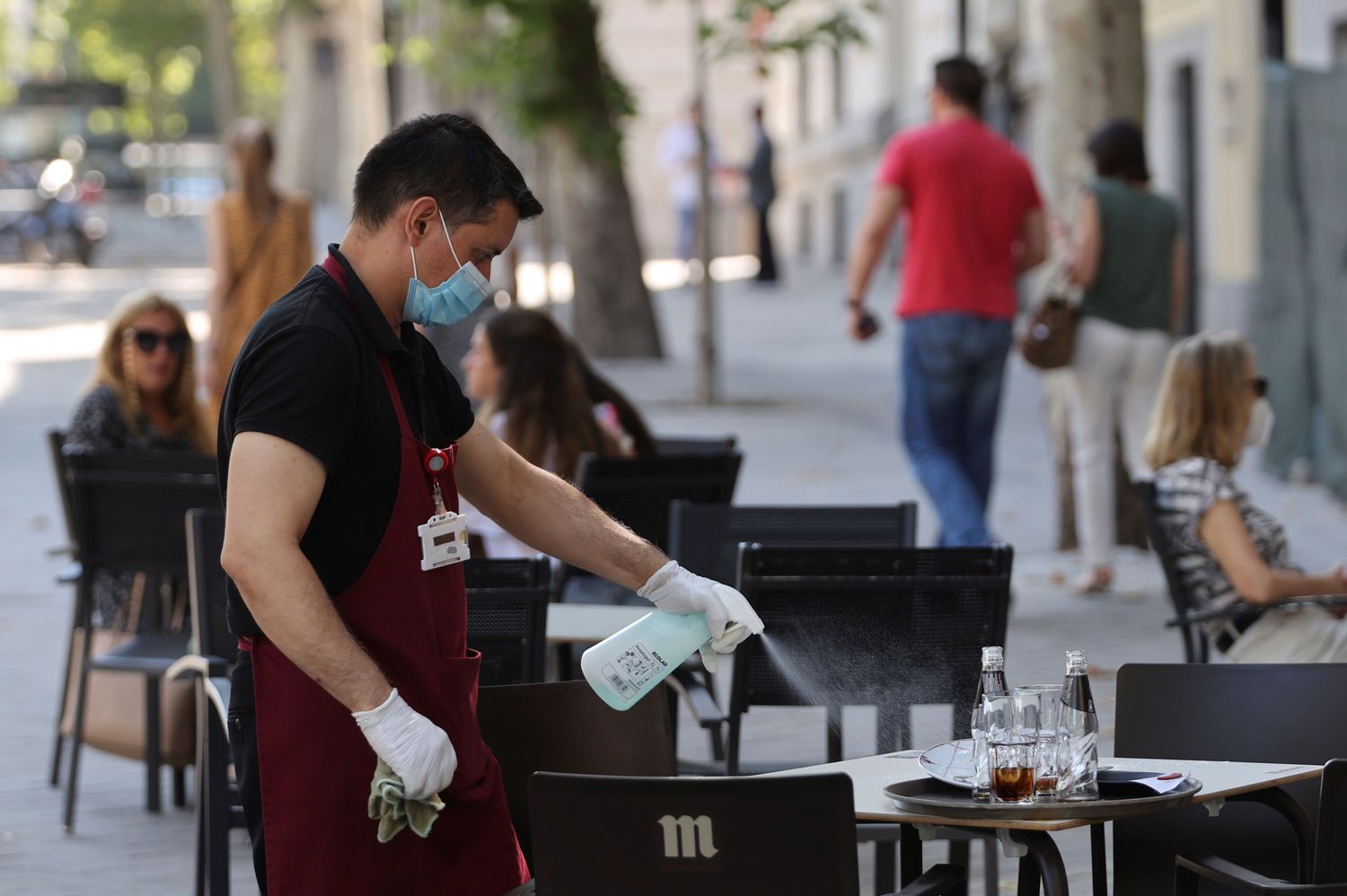 Un camarero desinfecta una mesa en la terraza de un bar en el centro de Madrid, este miércoles.