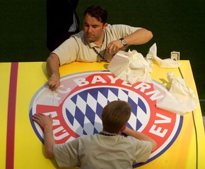 Unos trabajadores colocan un escudo del Bayern de Múnich, en el estadio de San Siro, un día antes de la final de la Copa de Europa contra el Valencia FC en 2001