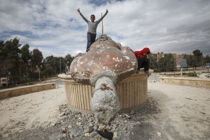 Unos ni&ntilde;os juegan en Raqqa con los restos de una estatua de Basil El Asad, hermano del presidente.