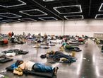 People rest at the Oregon Convention Center cooling station in Oregon, Portland on June 28, 2021, as a heatwave moves over much of the United States. - Swathes of the United States and Canada endured record-setting heat on June 27, 2021, forcing schools and Covid-19 testing centers to close and the postponement of an Olympic athletics qualifying event, with forecasters warning of worse to come. The village of Lytton in British Columbia broke the record for Canada's all-time high, with a temperature of 46.6 degrees Celsius (116 Fahrenheit), said Environment Canada. (Photo by Kathryn Elsesser / AFP)