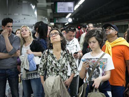Usuarios de Rodalies miran las pantallas informativas de Renfe en la estación de Sants de Barcelona.