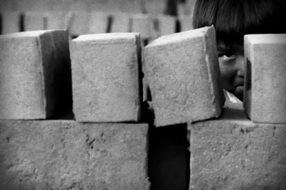 Un niño juega al escondite entre los ladrillos. En ocasiones, la ladrillera se convierte en espacio de juego.