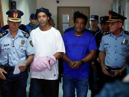 Ronaldinho y su hermano Roberto de Assis Moreira, escoltados por agentes paraguayos, en Asunción.