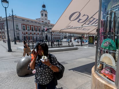 Una mujer en la Puerta del Sol se refresca con un helado, este lunes en Madrid.