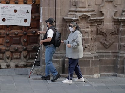 Dos personas ciegas caminan por el centro histórico de la Ciudad de México.