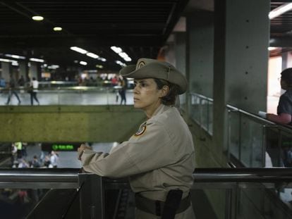 Carolina González, cabo de la milicia, observa a los usuarios del metro en la estación Altamira, en Caracas.