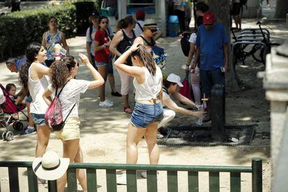 Varias jóvenes se refrescan para soportar la ola de calor en Madrid.