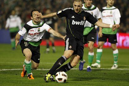 Benzema intenta un regate dentro del área del Racing zafándose del marcaje de Munitis.