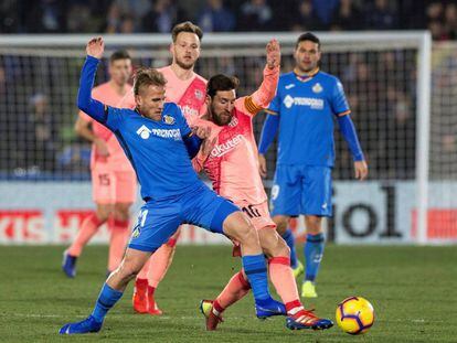 Messi lucha el balón con Ignasi Miquel.