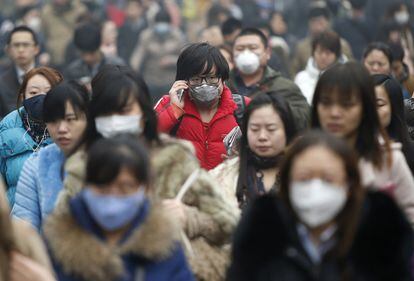 Ciudadanos cubiertos con mascarillas caminan por las calles de Pekín, una de las ciudades chinas afectadas por la contaminación