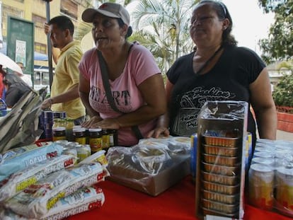 Un par de mujeres compran comida en un mercado estatal de Caracas.