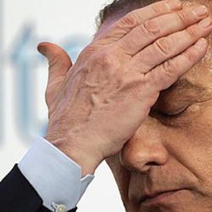 Silvio Berlusconi, llevándose la palma de mano a la frente