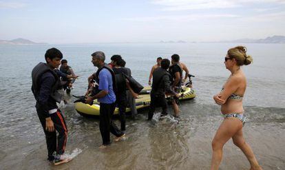 Una turista observa l'arribada de migrants a l'illa de Kos.