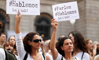 Dos mujeres sostienen carteles a favor del diálogo este sábado en Barcelona.