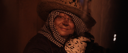 Cristina García Rodero, en una imagen del documental con la cara tiznada y cubiertas la cabeza y las manos para protegerse de las llamas durante una fiesta.