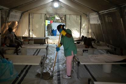 Una empleada sanitaria limpia dentro de una carpa donde las personas que sufren síntomas de cólera son tratadas en una clínica dirigida por Médicos Sin Fronteras, en Puerto Príncipe.
