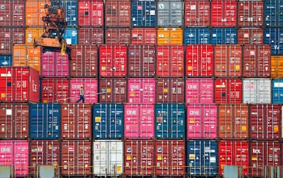 Un trabajador camina sobre pilas de contenedores en el puerto de Tanjung Priok en Yakarta (Indonesia).