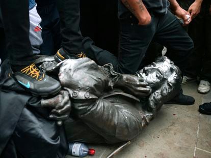 Un manifestante hinca su rodilla en el cuello de la estatua derribada de Edward Colston, este domingo en Bristol (Reino Unido).