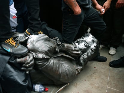 Un manifestante hinca su rodilla en el cuello de la estatua derribada de Edward Colston, este domingo en Bristol (Reino Unido).