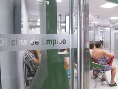 Varias personas esperan su turno en la oficina de empleo del barrio de Amate, en Sevilla.