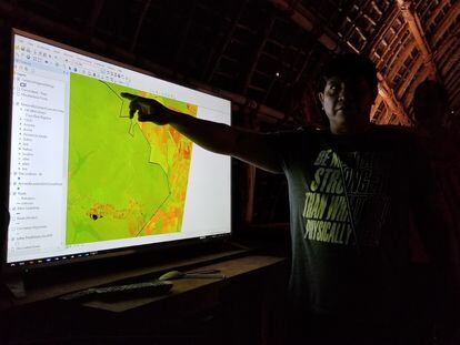 Yanamá Kuikuro muestra en una pantalla la aplicación usada para rastrear los casos positivos de coronavirus en la aldea Ipatse, en Xingú.