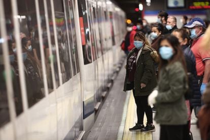 Viajeros con mascarillas en un andén de la estación de metro de Nuevos Ministerios este lunes.