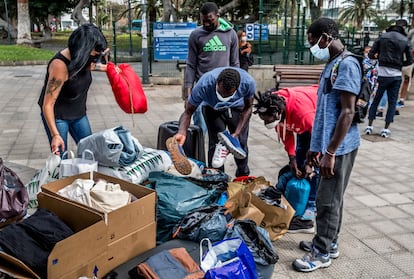 Jóvenes senegaleses recogen ropa donada por los ciudadanos en una iniciativa de la plataforma ciudadana Somos Red, en febrero en Gran Canaria.