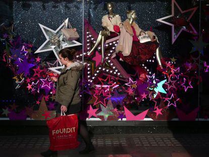 Una mujer camina con un bolso de compras en Londres. 
