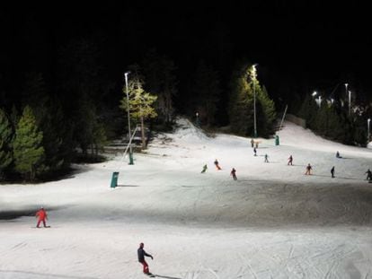 Esquiadors a l'estació de la Masella, il·luminada a la nit.