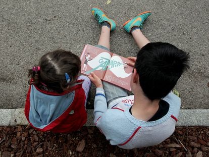 Niños leyendo un libro en una imagen de archivo.