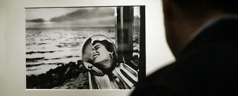 Un hombre observa en la exposición de la Fundación Canal la fotografía<i> California, 1955</i>, de Elliott Erwit.