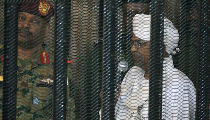 Al Bashir asiste ebtre rejas a una vista judicial en Jartum el pasado diciembre.