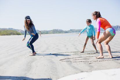 Instructor Maria del Mar Alfaro teaches a mother and daughter the basics of surfing at Guiones Beach in Nosara, Guanacaste.