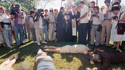 Un arzobispo y un grupo de periodistas junto a los cuerpos, en 1989.
