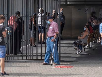 Varios usuarios esperan para acceder al centro de salud El Alamillo, este martes, en Sevilla.